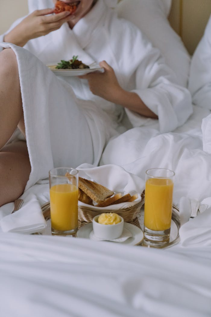 Experience a luxurious morning with breakfast in bed, featuring fresh orange juice and toast.