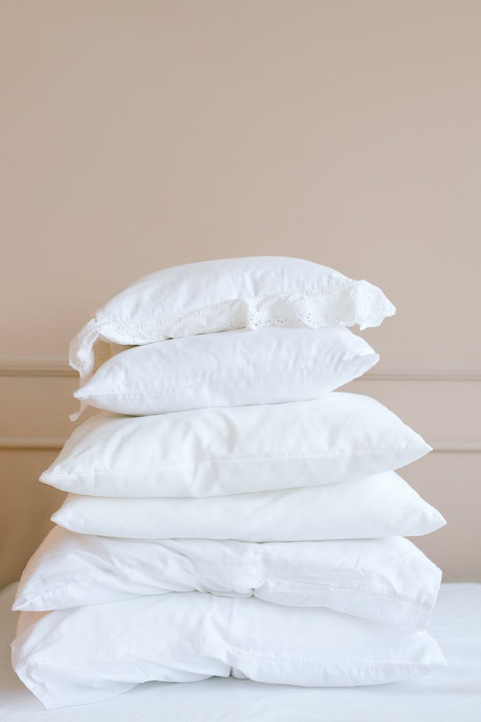 gallery-4 A stack of white pillows on a neutral background, showcasing elegance and simplicity.
